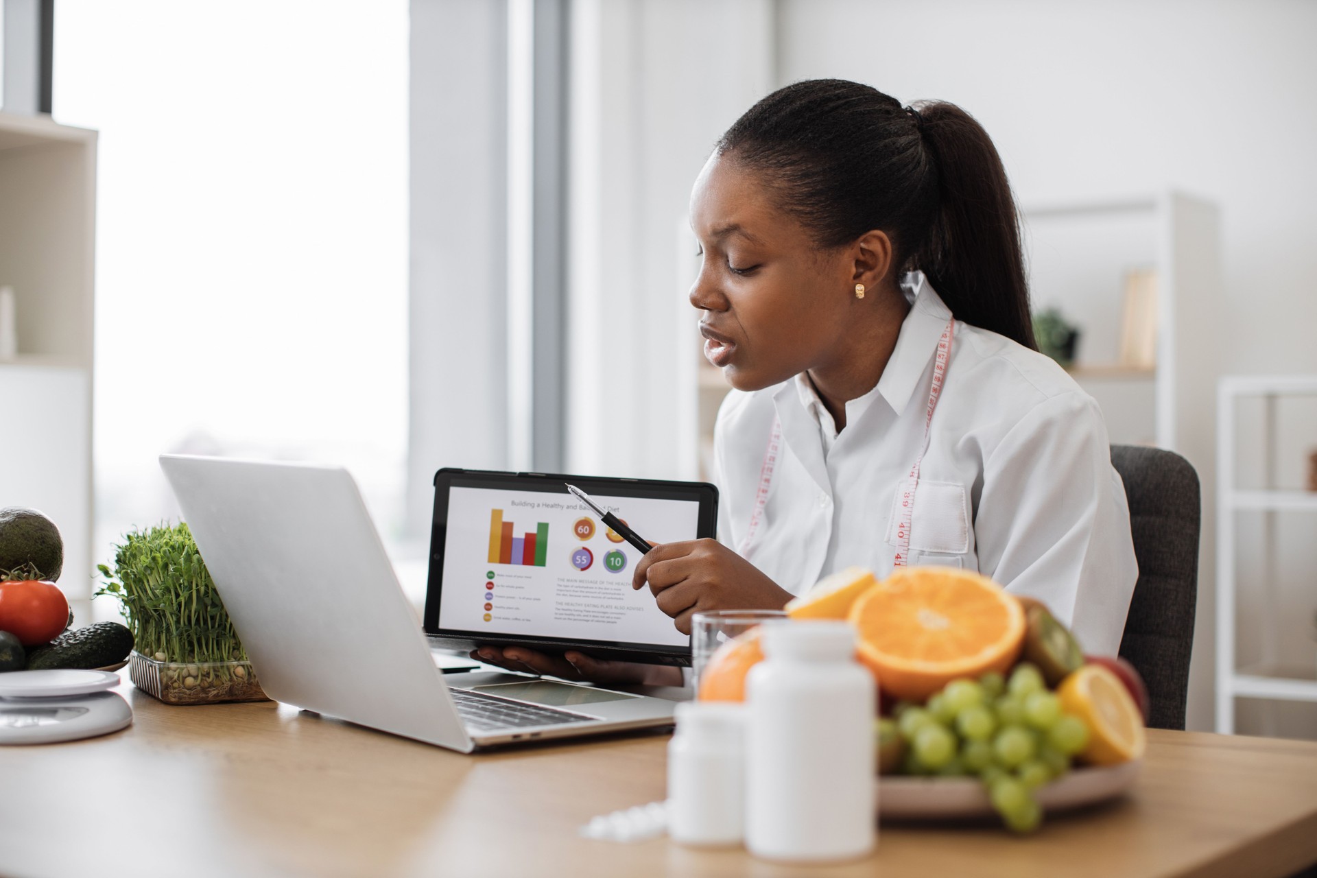 Expert with meal plan on tablet meeting with client online